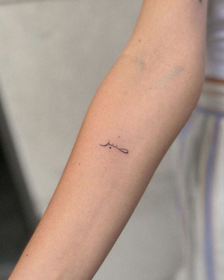 a person's arm with a small tattoo on the left side of their arm