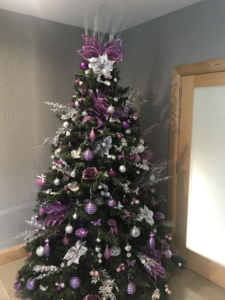 a decorated christmas tree with purple and silver decorations