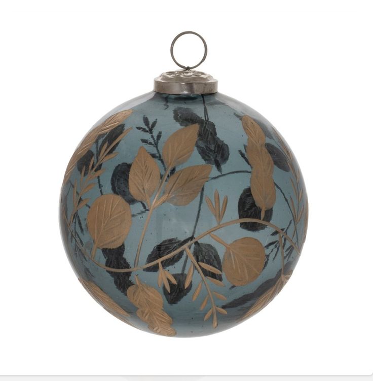 a blue ornament with leaves and branches painted on the front, hanging from a metal rod