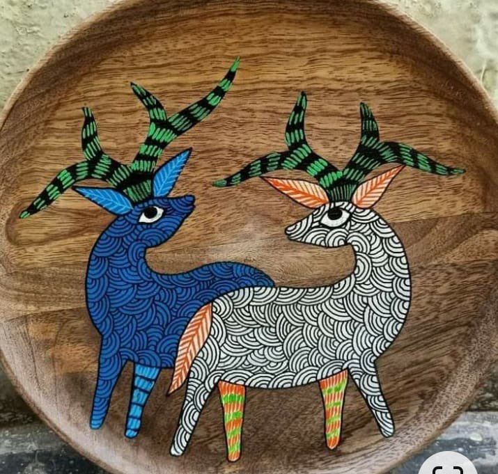 a wooden bowl with two deers painted on it