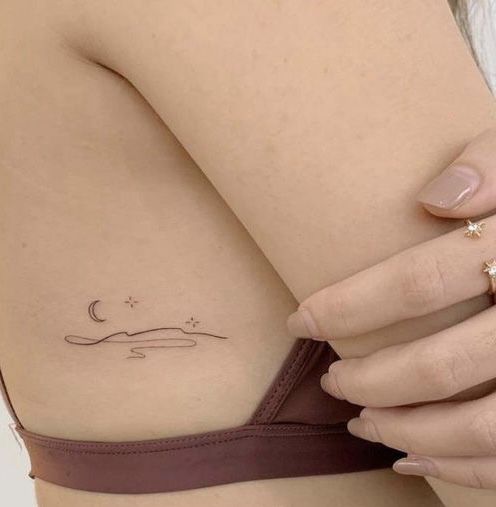 a woman's arm with a small tattoo on the left side of her body