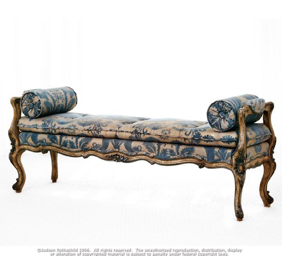 an ornate bench with blue and white fabric on it's back legs, in front of a white background