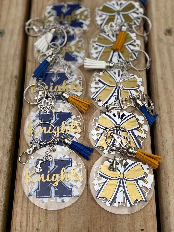 several key chains with different designs on them sitting on a wooden table next to each other