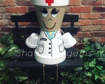 a statue of a nurse sitting on a bench in front of a brick wall with ivy growing around it