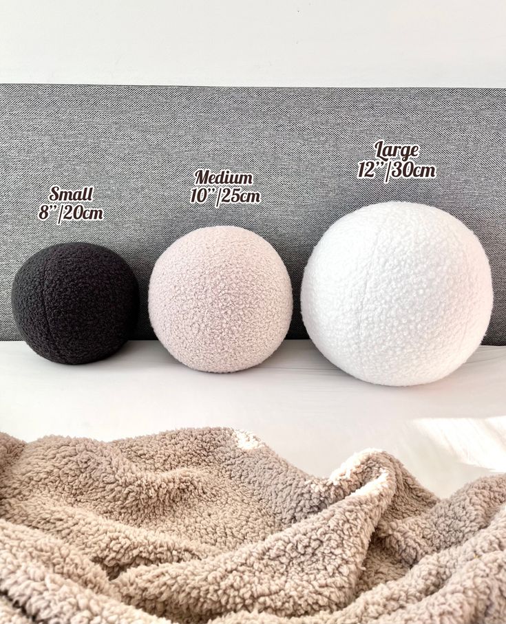 three different sizes of balls on a bed with the same size as shown above them