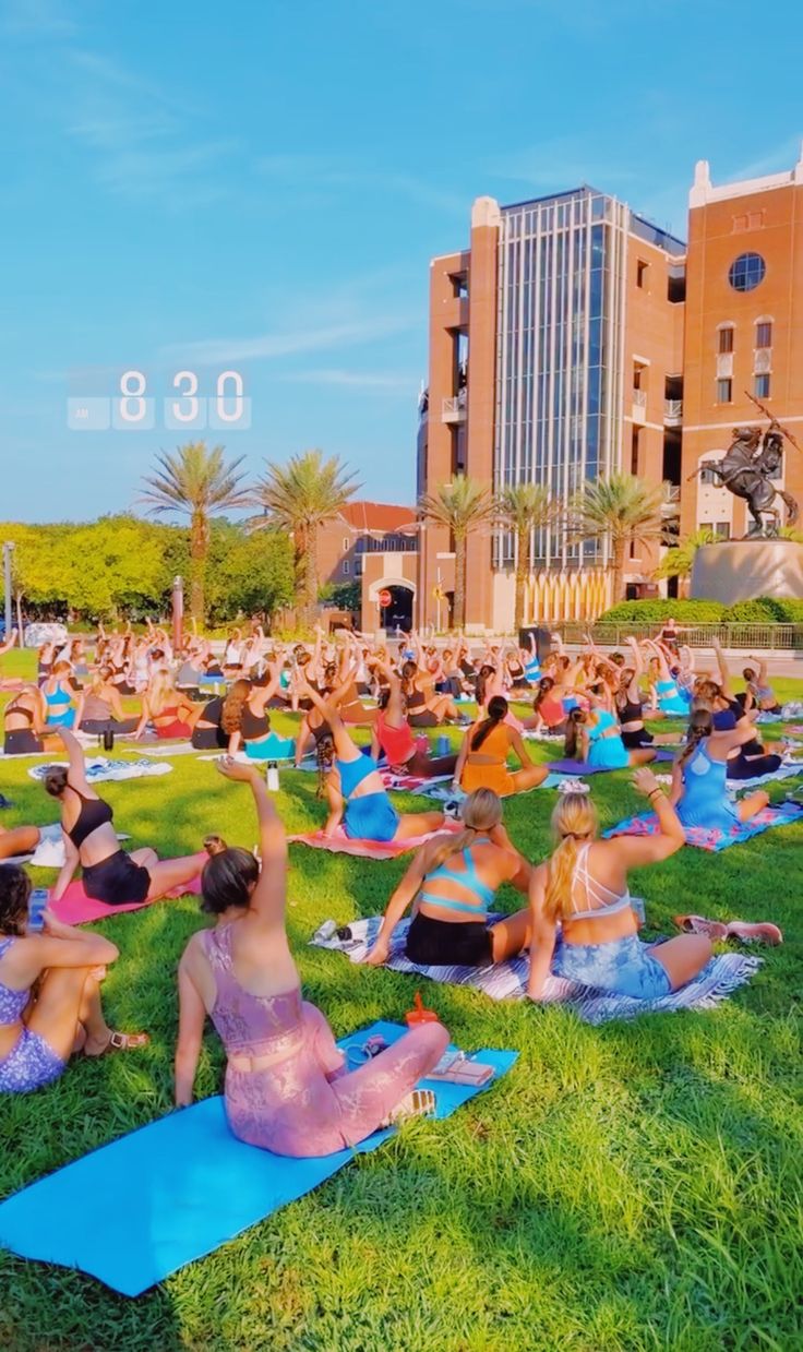 a large group of people are doing yoga in the grass on their stomachs and arms