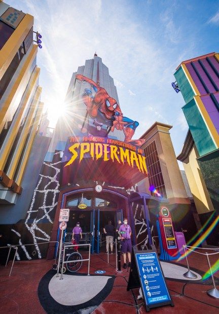 people are standing in front of the entrance to spider man