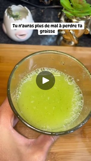 a person holding a glass filled with green liquid