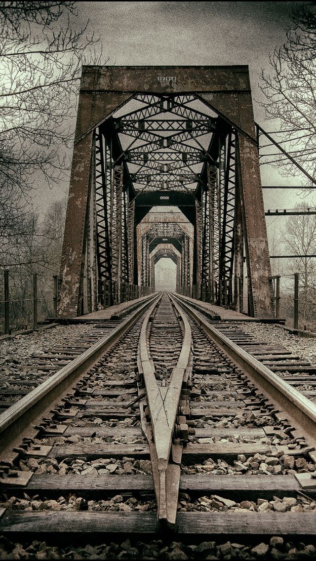 an old train track going under a bridge