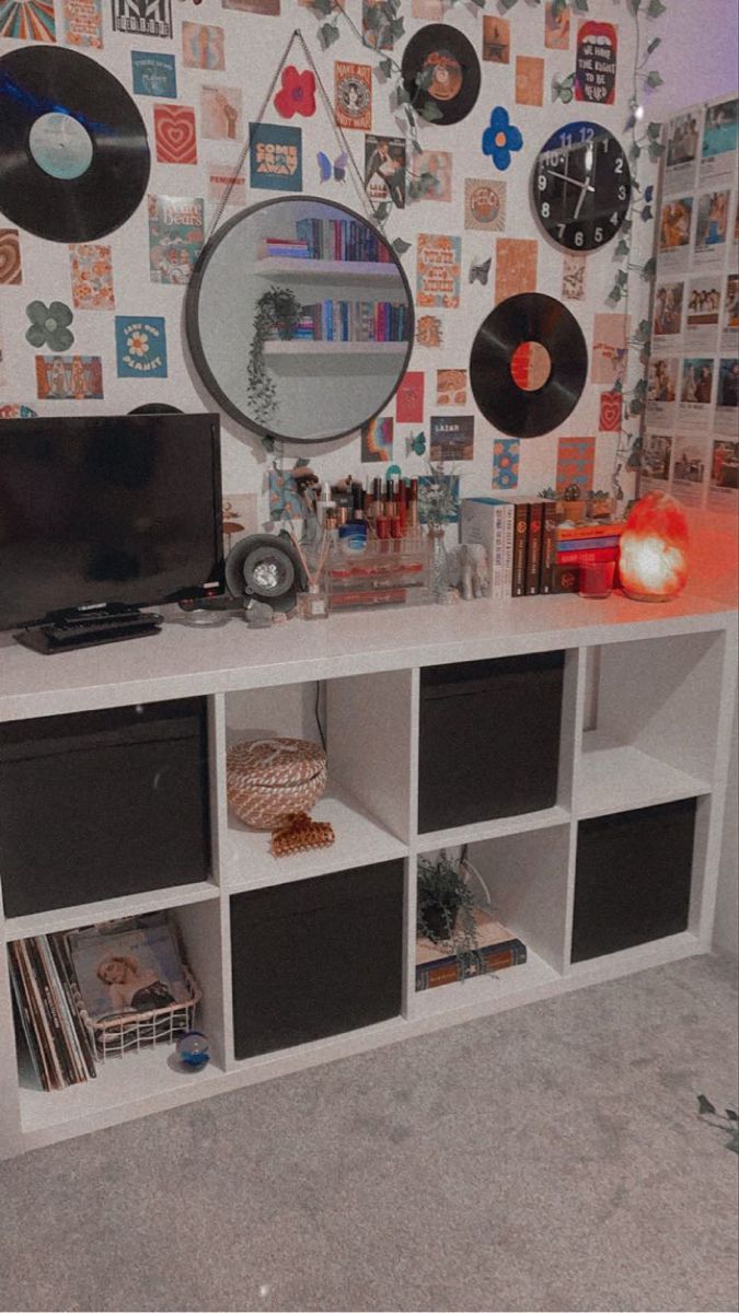 a white entertainment center with record players and records on the wall