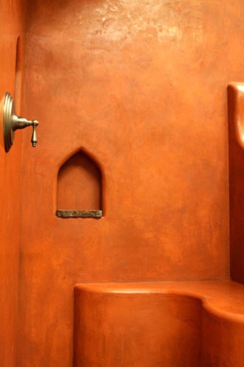 an orange wall with a door and window in the corner, next to some steps