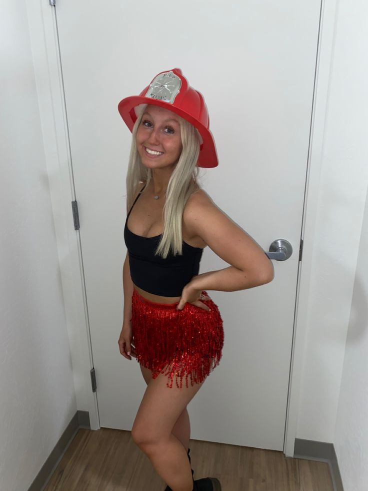 a woman wearing a fireman hat and red fringe skirt