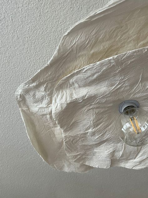 a light that is hanging from the ceiling with some paper on it's side