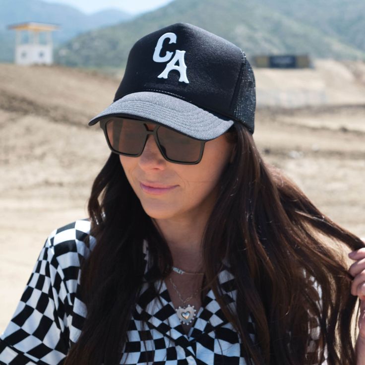 Our trucker style hat is the perfect accessory for errands, a playdate, the big soccer game or basically any occasion at all. *ALL HATS ARE FINAL SALE* 100% POLYESTER - One size fits most - Foam front, mesh back and terry sweatband - Black Otto 39-165 hat - Custom white puff lettering "CA" - Adjustable snap back Care Instructions: Spot clean only. Can be gently steamed if bent or creased. Summer Mesh Trucker Hat For Sports Events, Casual Mesh Trucker Hat For Baseball, Black Trucker Hat With Curved Bill For Game Day, Black Trucker Snapback Hat For Sports Events, Black Trucker Snapback Hat For Sports, Casual Trucker Hat With Mesh Back For Baseball Season, Black Trucker Hat For Sports Events, Sporty Summer Trucker Hat, Black Trucker Baseball Cap With Visor