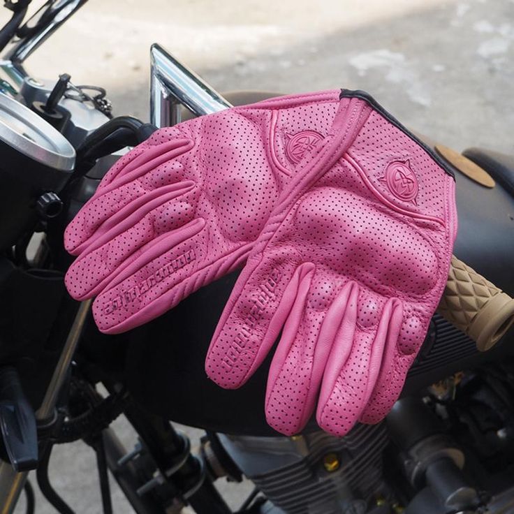 a pair of pink gloves sitting on top of a motorcycle