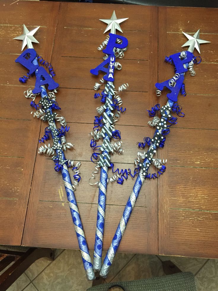 three blue and white straws with stars on them sitting next to each other in front of a wooden table