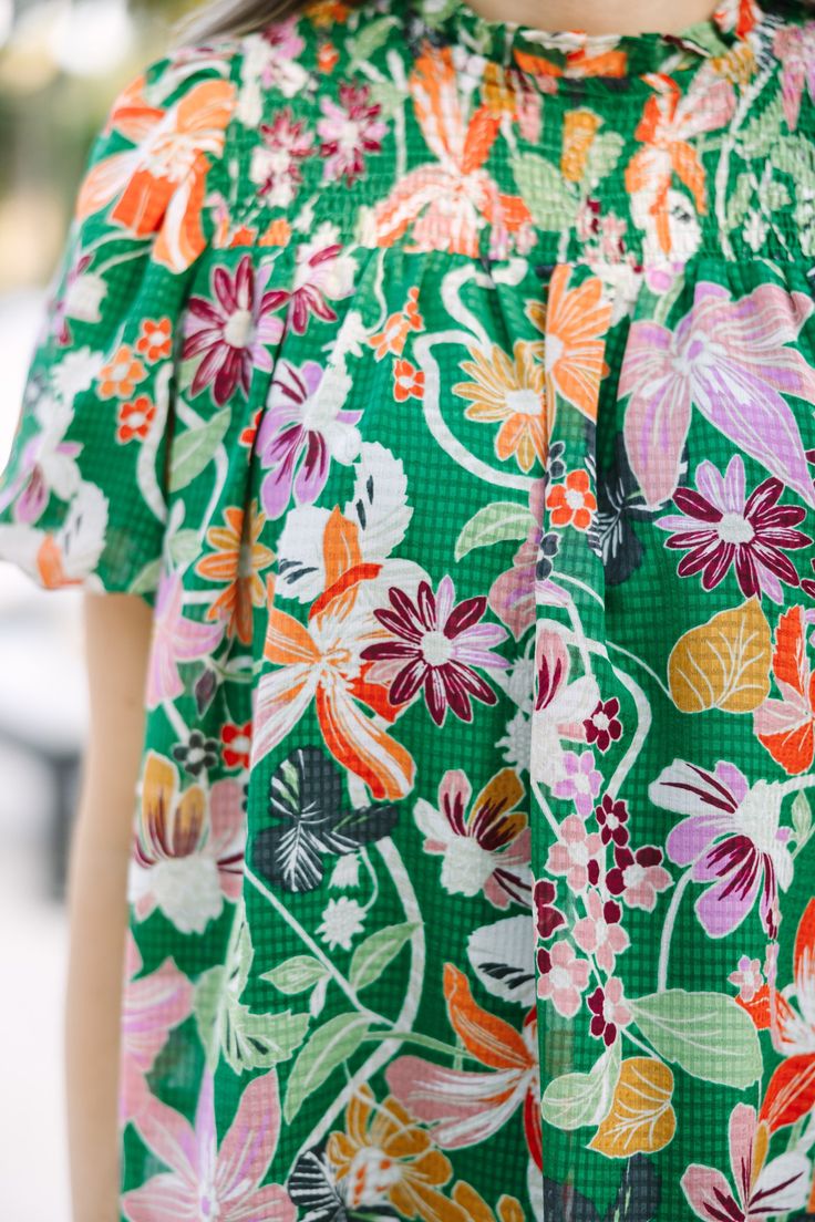 We hope you have all the plans for this blouse! It's sure to take you from the office to the beach side restaurant! That tropical floral print is so fun and colorful! Round neckline Smocked yoke Button keyhole back Short bubble sleeves Tropical floral print No stretch Savannah is wearing the small. Green Hawaiian Top For Spring, Green Vibrant Print Summer Blouse, Spring Hawaiian Green Top, Green Beach Top With Smocked Back, Summer Green Blouse With Vibrant Print, Summer Blouse With Vibrant Green Print, Beach Green Top With Smocked Back, Hawaiian Blouse For Spring Vacation, Green Top With Smocked Back For Beach