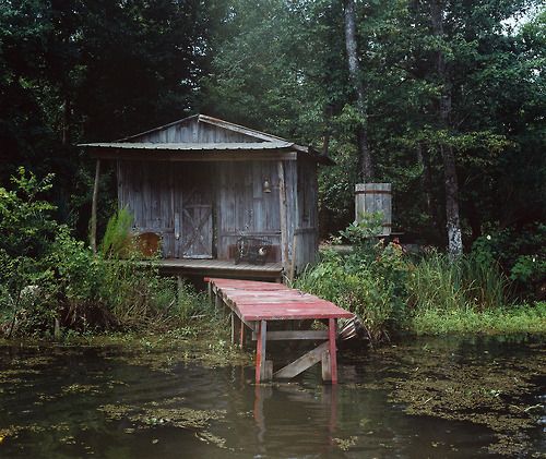 a boat dock in the middle of a body of water with a shed on it