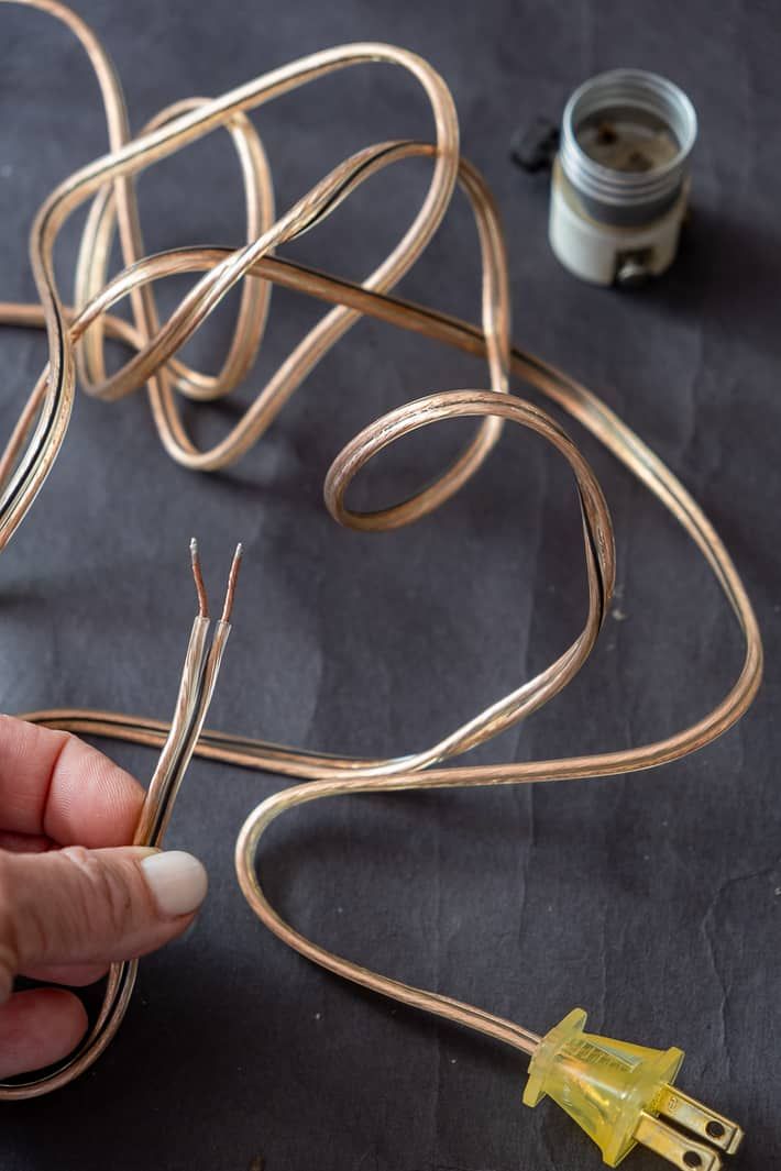 a person is working on some kind of wire sculpture with gold colored wires attached to it