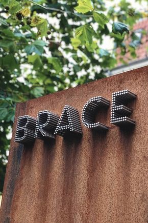 a close up of a sign on the side of a building with trees in the background