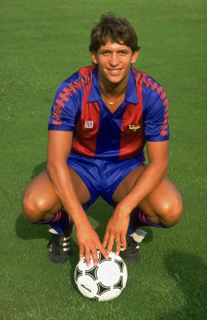 an autographed soccer player sitting on the ground with his ball in front of him