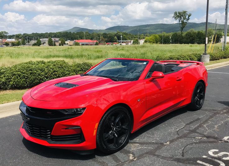 a red chevrolet camaro parked in a parking lot