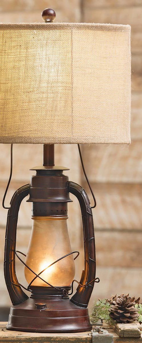 a lamp that is sitting on top of a table next to a pinecone