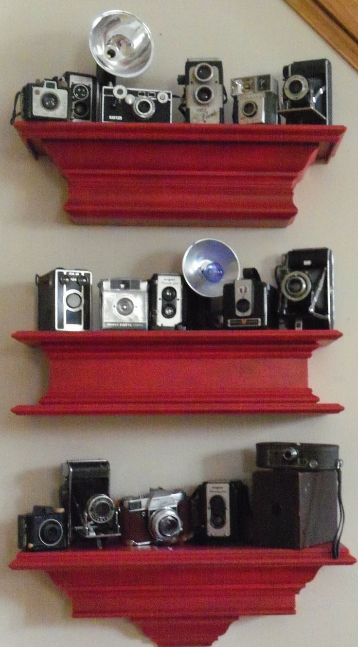 three red shelves with cameras on them