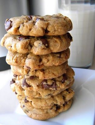 a stack of cookies sitting on top of a white plate next to a glass of milk