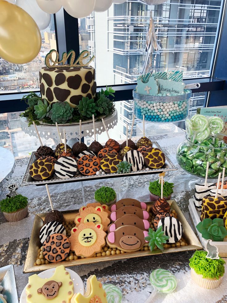 an assortment of desserts displayed on three tiered trays in front of a window