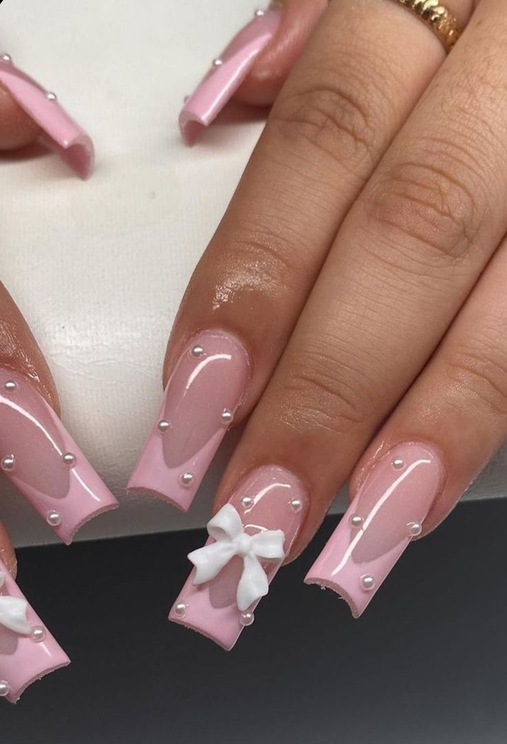 a woman's hands with pink and white nail designs