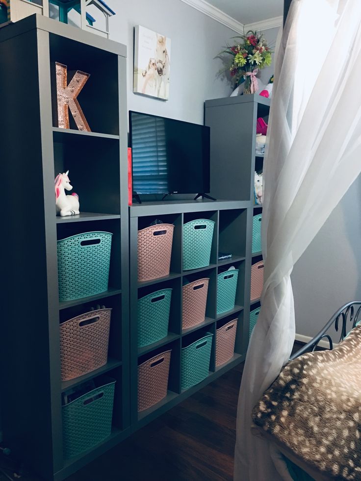 a room with several storage containers and a bed