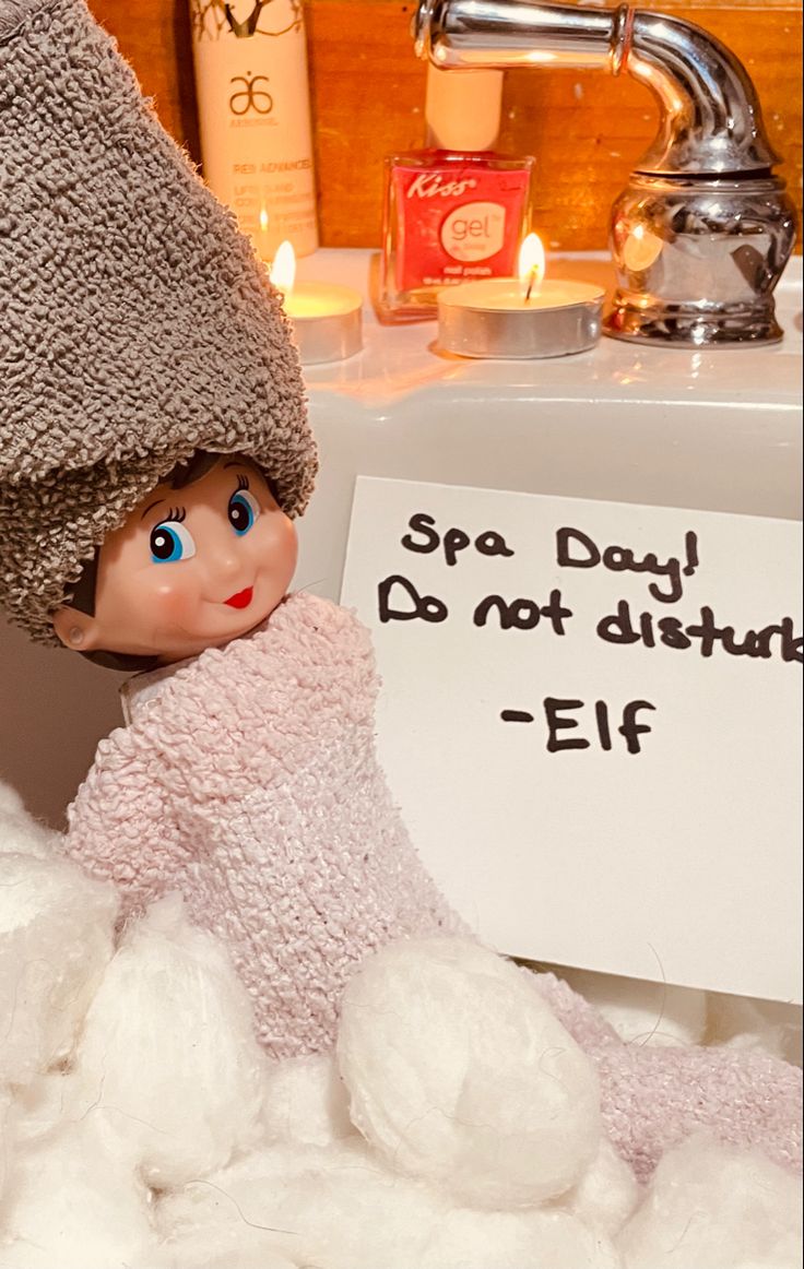 an elf is sitting in the middle of a pile of cotton next to a sign that says spa day do not disturb