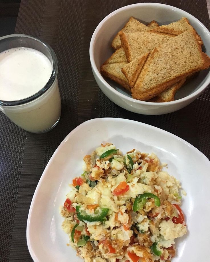 there is a plate of food and a glass of milk next to it on the table