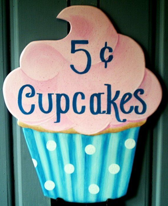 a cupcake sign hanging on the side of a door