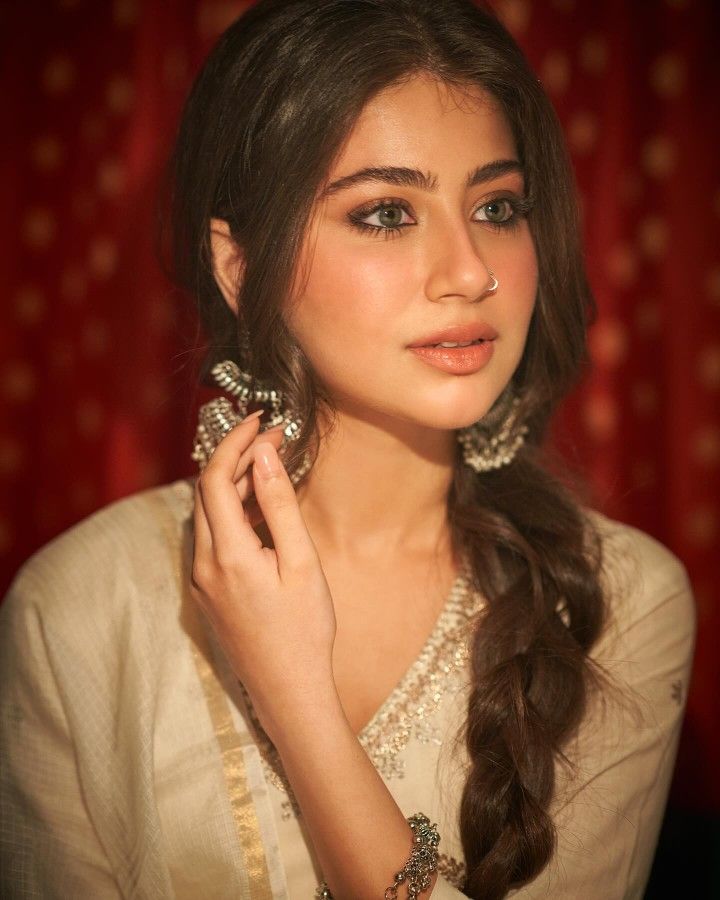 a beautiful young woman with long hair wearing jewelry