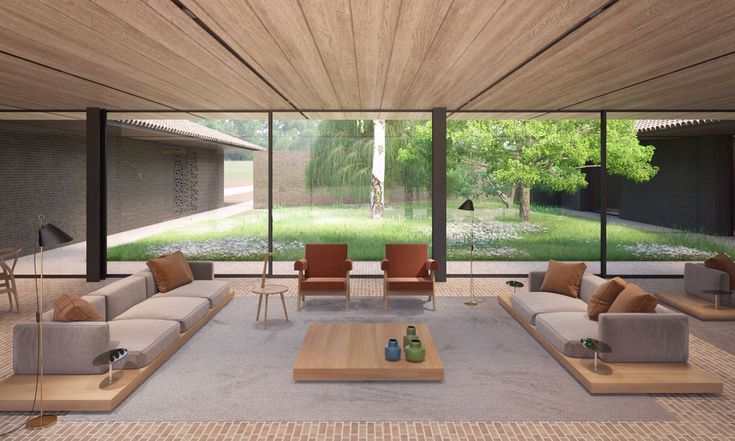 a living room filled with lots of furniture next to a large glass wall covered in windows