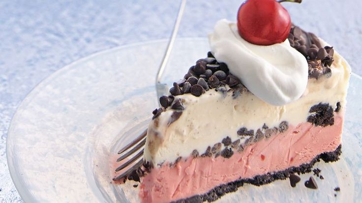 a piece of cake on a plate with a cherry on top and chocolate chips around it