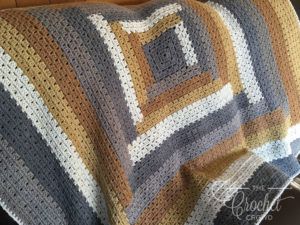 a crocheted blanket sitting on top of a couch