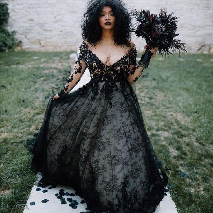 a woman in a black dress holding flowers