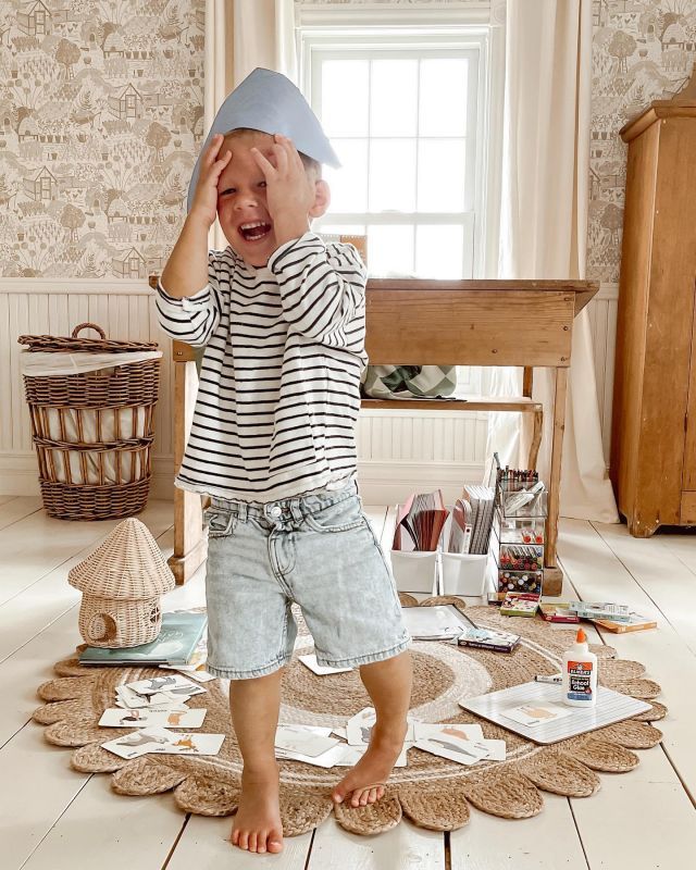 a little boy standing on top of a wooden floor