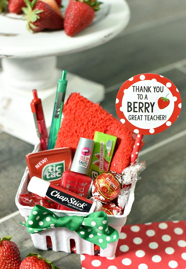 a basket filled with lots of different types of items next to some strawberries on a table