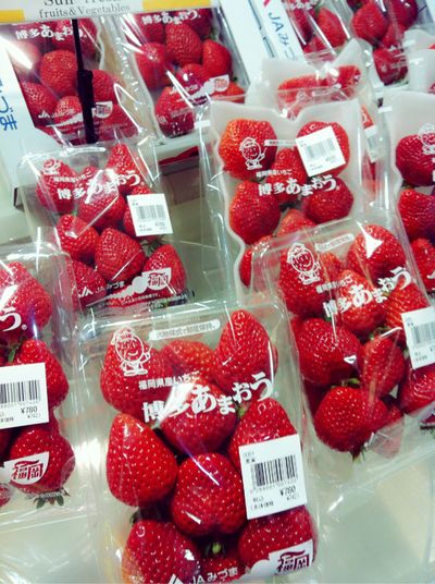 bags of strawberries are on display at a grocery store in japan for $ 3 99 each