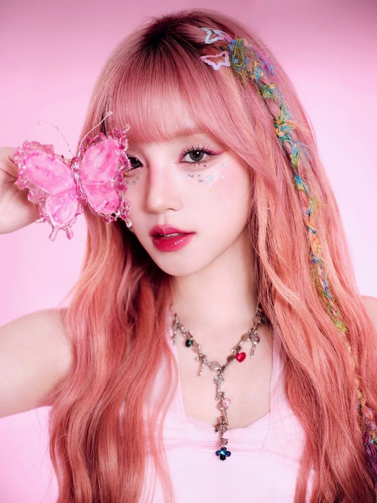 a woman with long pink hair and butterfly decorations on her head is posing for the camera