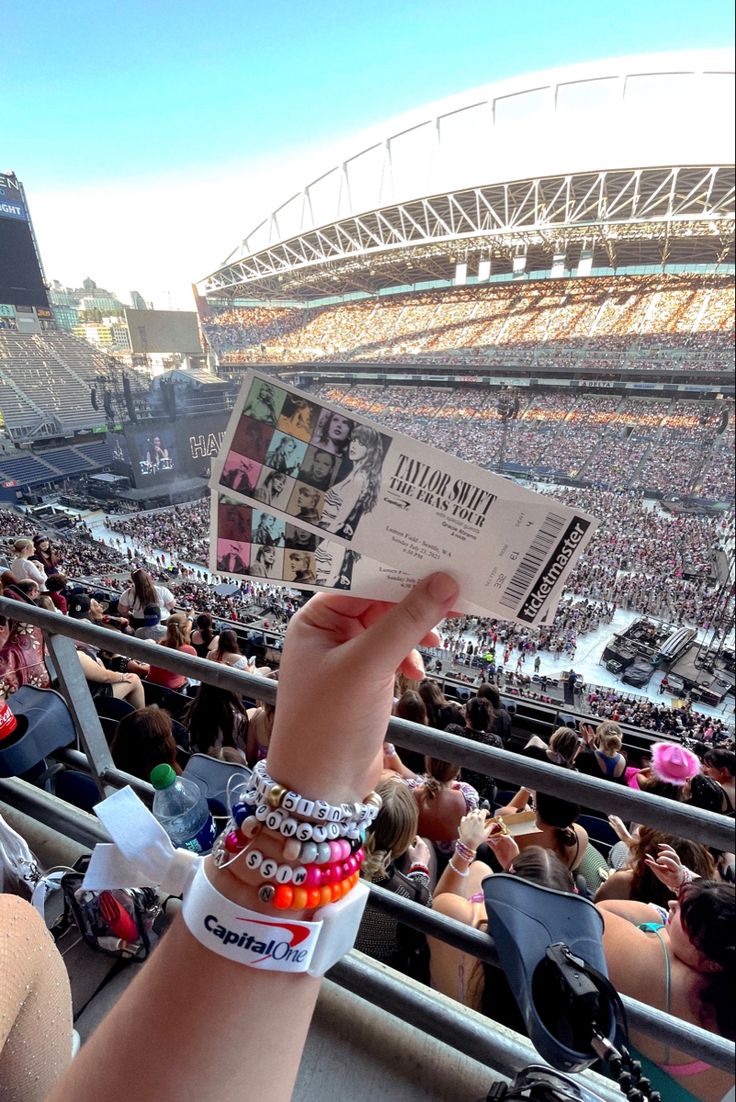 a person holding up a paper in front of an audience at a concert or sporting event