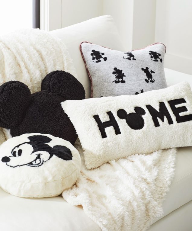 mickey mouse pillows on a couch with the word home