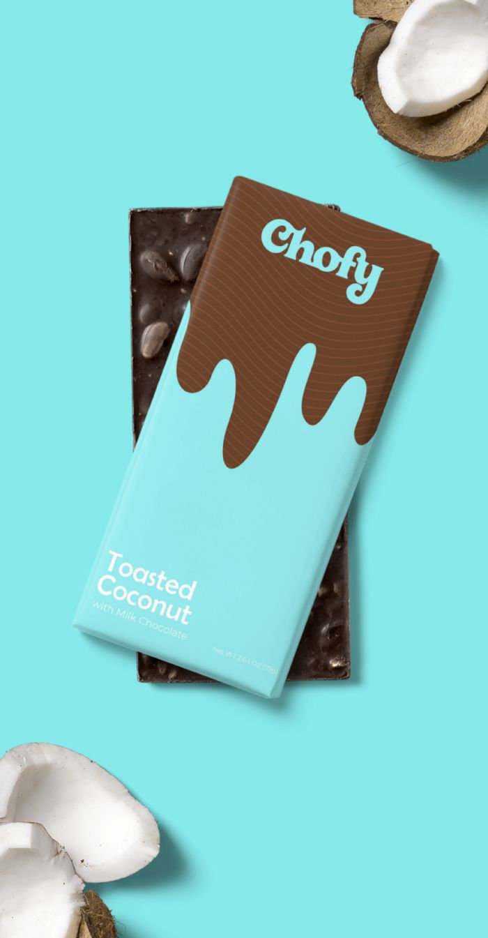 the chocolate bar is next to some coconuts on a blue background with white and brown icing