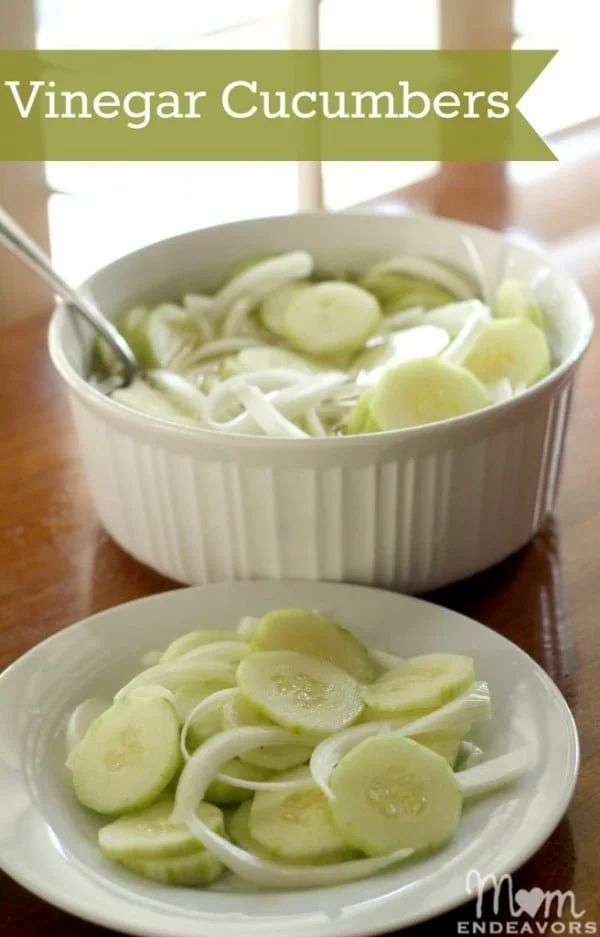 two white bowls filled with sliced cucumbers on top of a wooden table next to a window