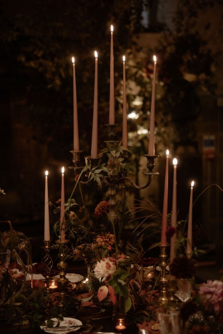 a table topped with lots of candles and plates