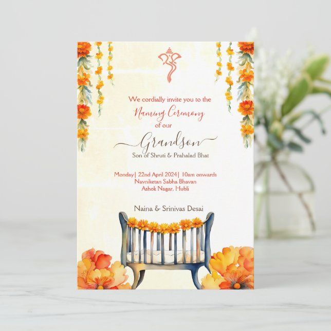 an orange and yellow wedding card with flowers on the front, sitting next to a vase